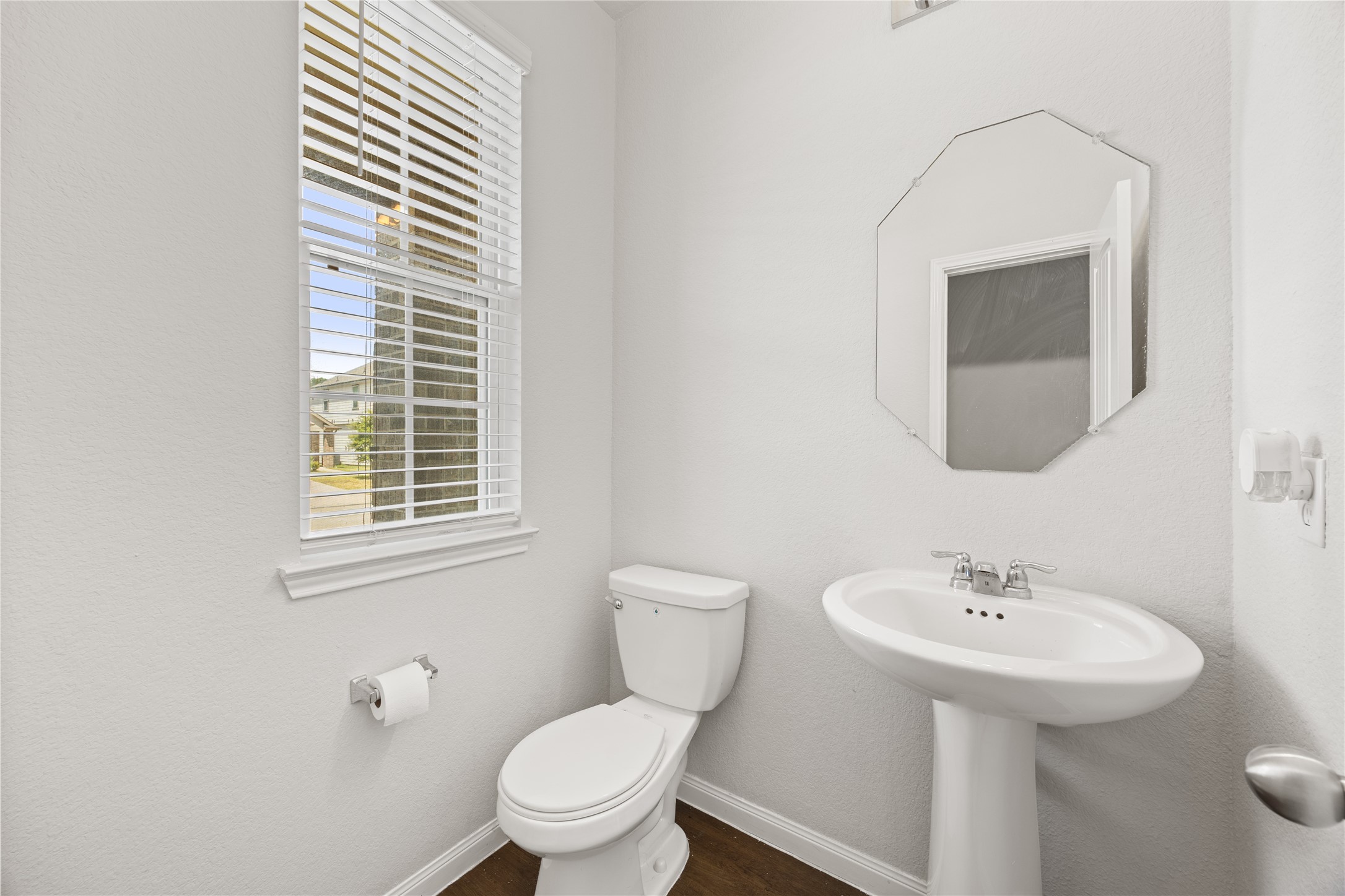 17514 Cuthbert Street Humble, TX 77346 - Photo 13 of 19 Bright and airy half-bathroom featuring a pedestal sink, classic white fixtures, and a window inviting natural light.
