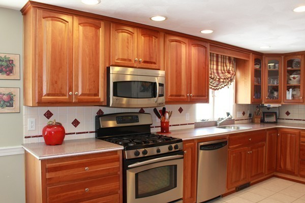 198 Proctor Road Chelmsford, MA 01824 - Photo 8 of 30 a kitchen with granite countertop wooden cabinets and a stove top oven