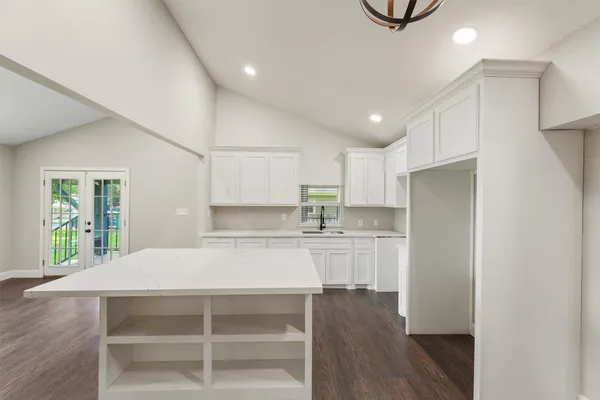 a view of a kitchen with a fridge and wooden floor