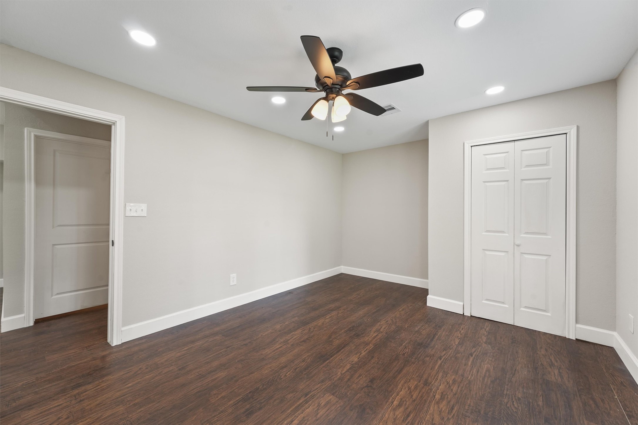 905 Franconia Drive Conroe, TX 77316 - Photo 9 of 12 an empty room with wooden floor fan and windows