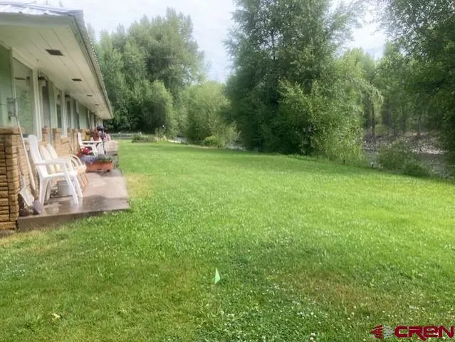 a view of a patio with table and chairs a barbeque and a small yard
