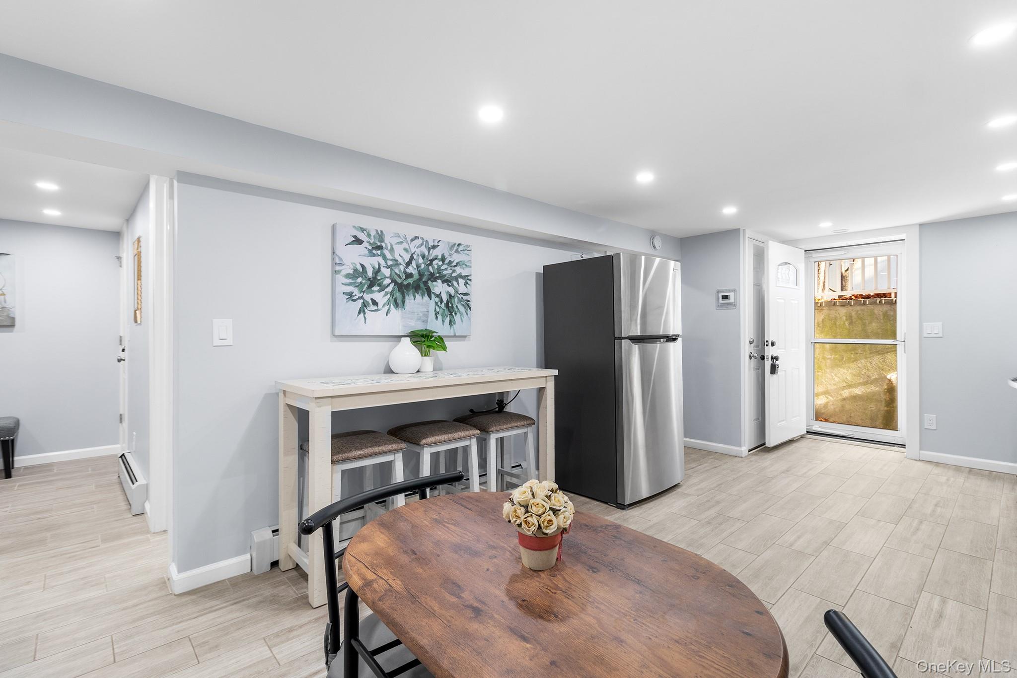 164 Colonial Springs Road Wheatley Heights, NY 11798 - Photo 13 of 35 a kitchen with stainless steel appliances refrigerator dining table and chairs