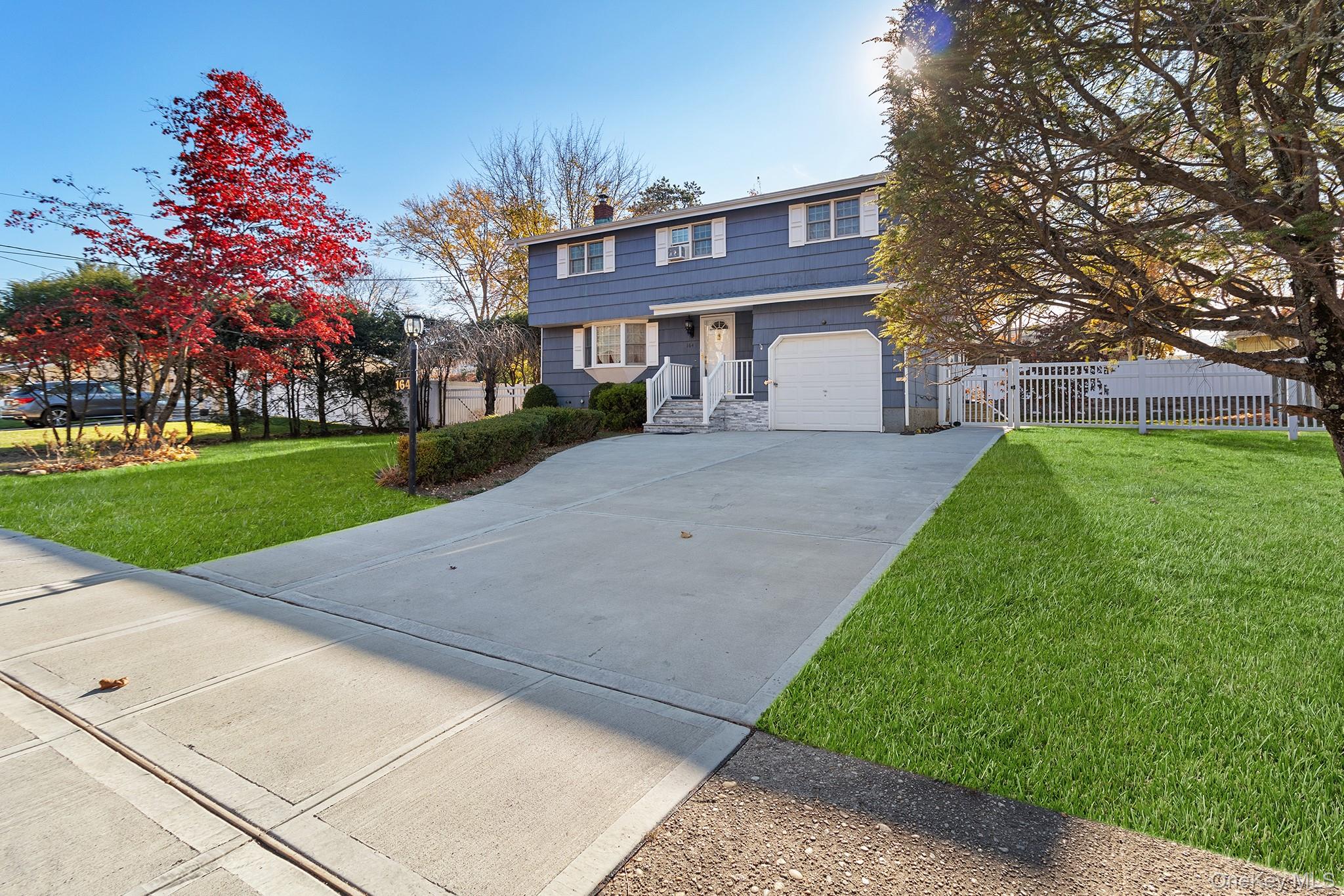 164 Colonial Springs Road Wheatley Heights, NY 11798 - Photo 2 of 35 a front view of a house with a yard and trees