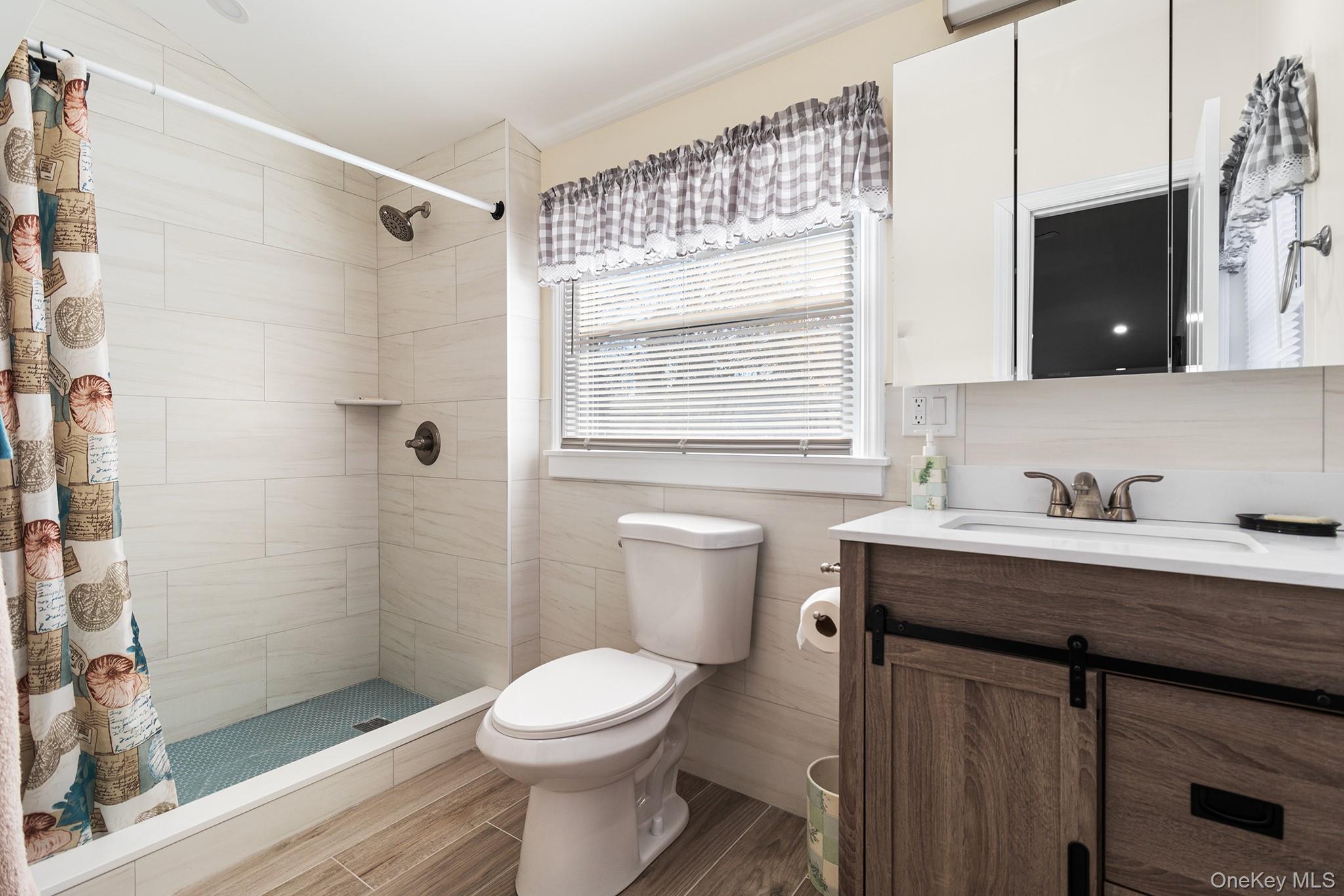 164 Colonial Springs Road Wheatley Heights, NY 11798 - Photo 27 of 35 a bathroom with a granite countertop sink toilet a mirror and shower