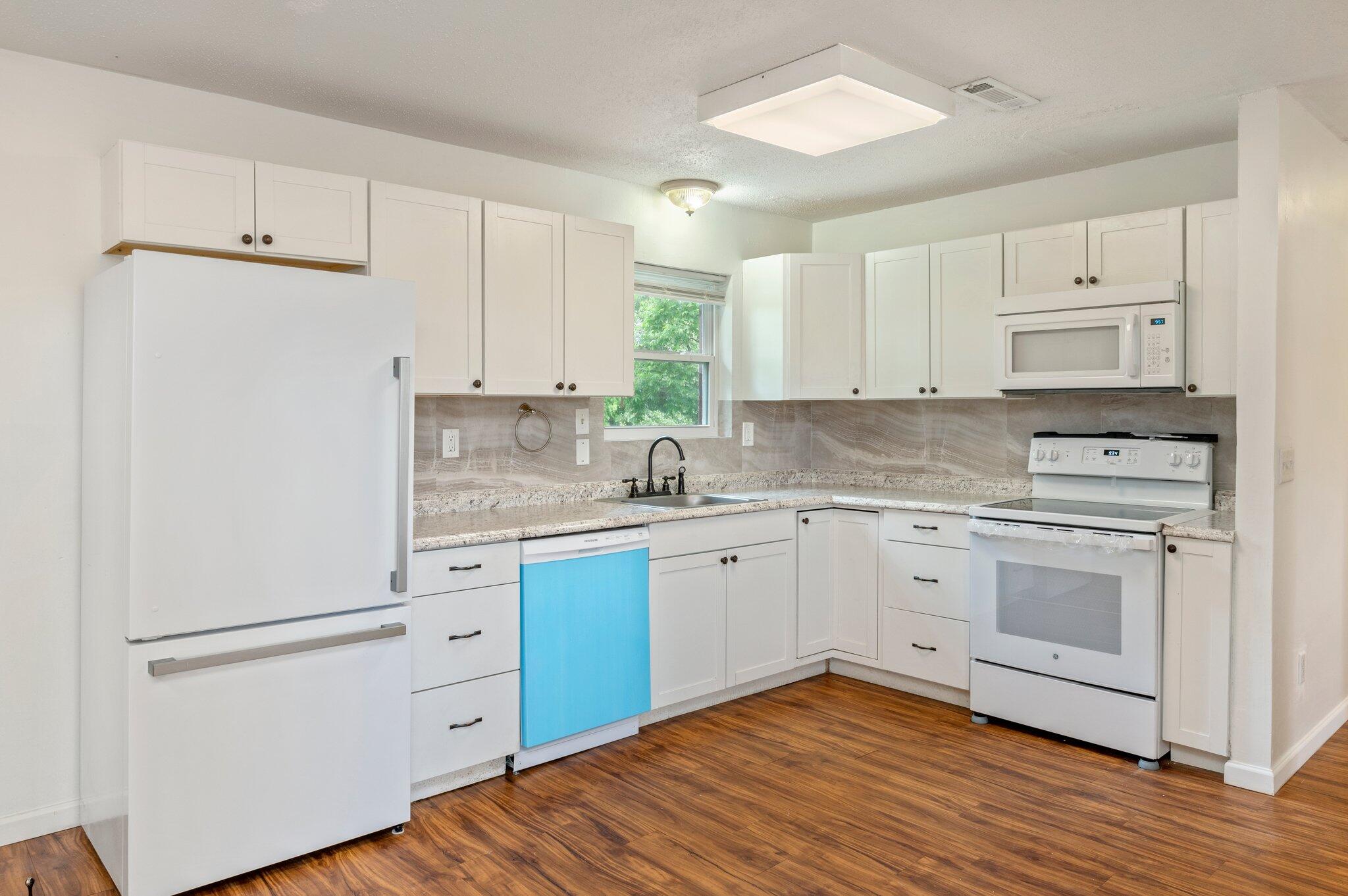 1099 Highway 2 Westville, FL 32464 - Photo 12 of 34 a kitchen with granite countertop white cabinets and white appliances