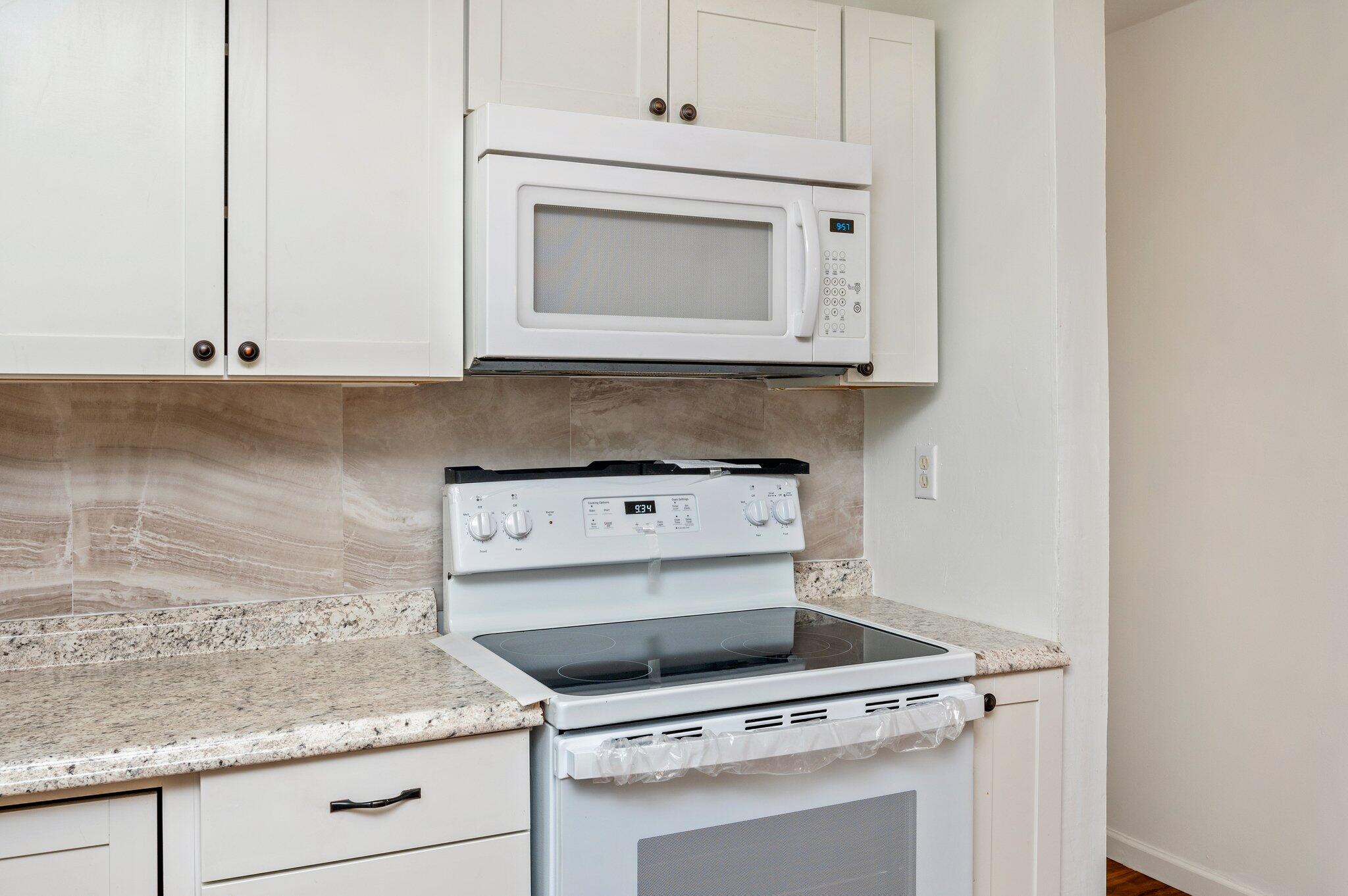 1099 Highway 2 Westville, FL 32464 - Photo 15 of 34 a kitchen with a stove and white cabinets