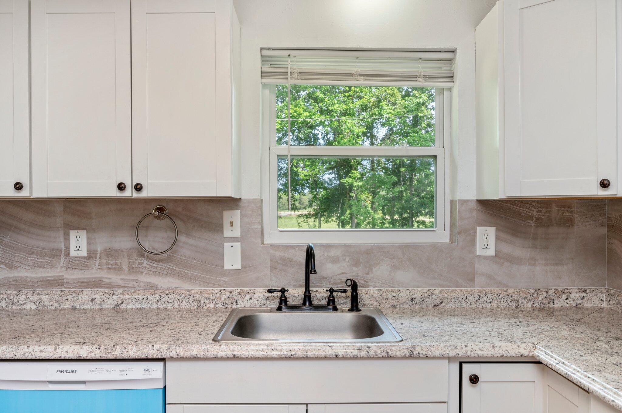 1099 Highway 2 Westville, FL 32464 - Photo 16 of 34 a kitchen with granite countertop a sink a window and cabinets