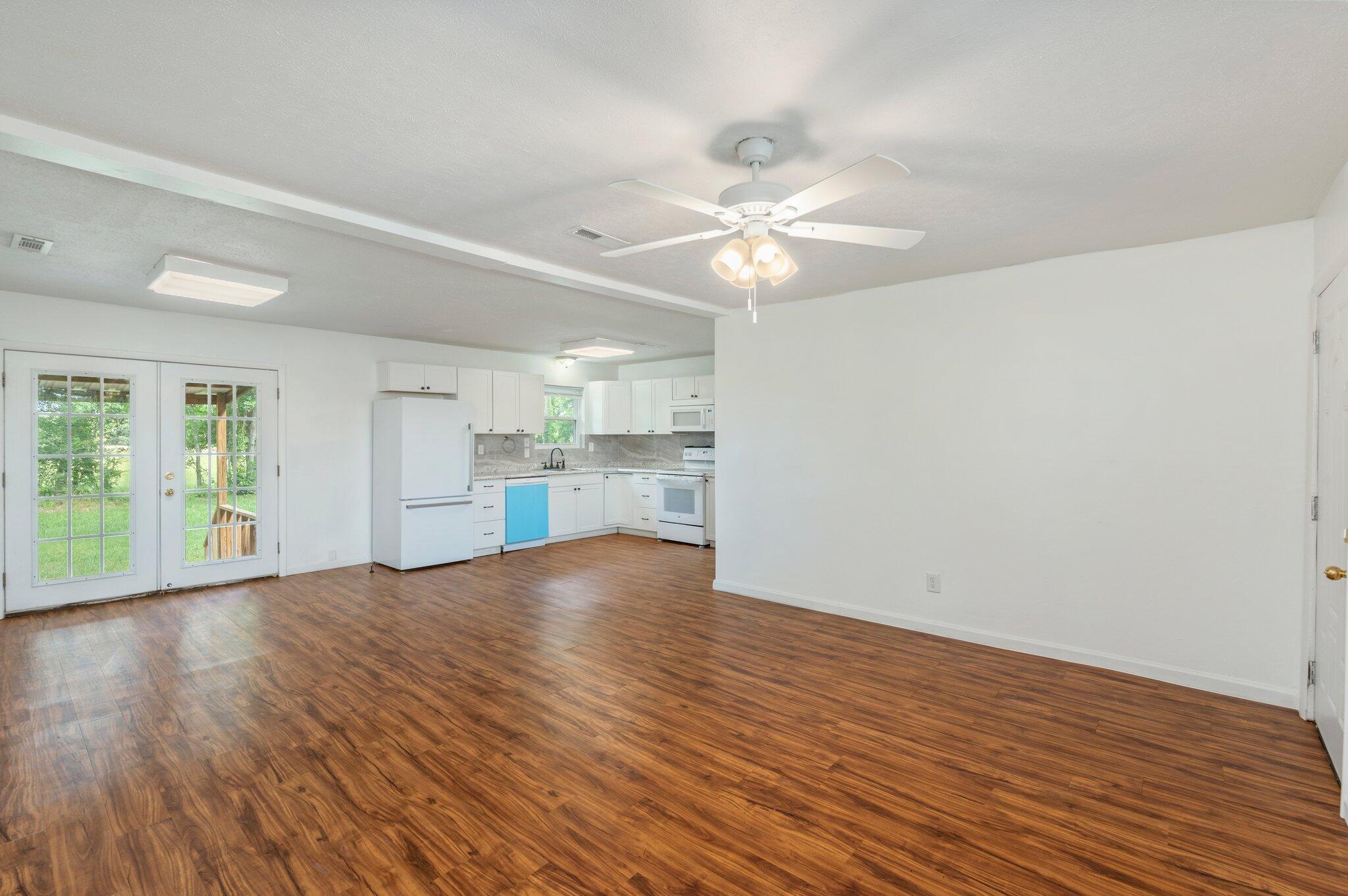 1099 Highway 2 Westville, FL 32464 - Photo 10 of 34 an empty room with wooden floor fan and windows