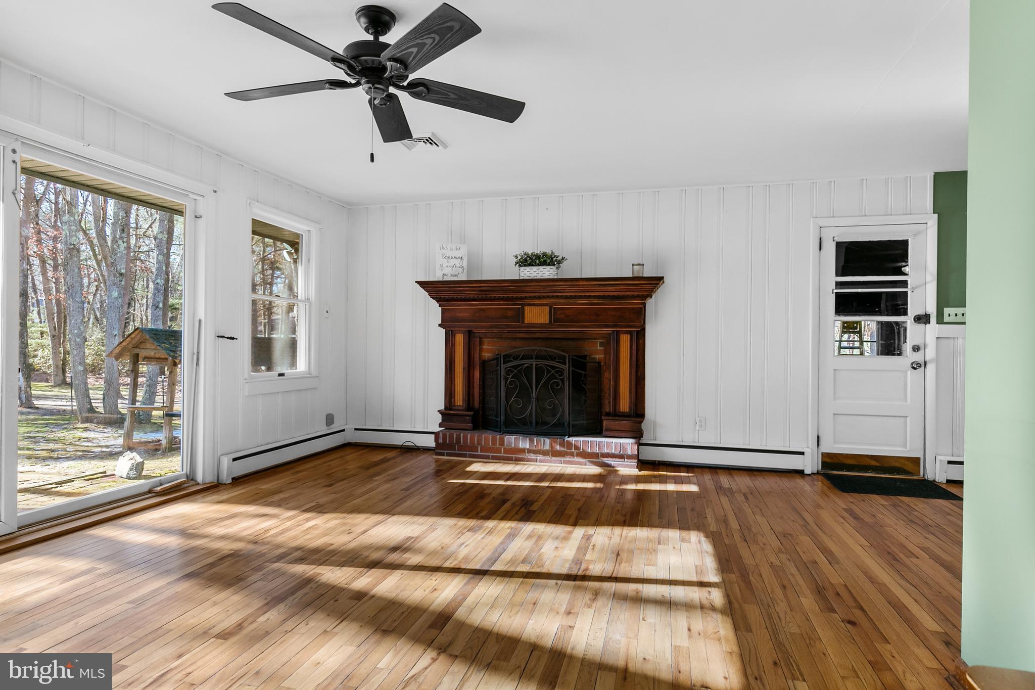 1358 Stokes Road Medford, NJ 08055 - Photo 7 of 36 a living room with a fireplace windows and a ceiling fan