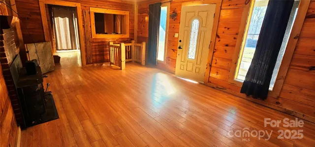 a view of a room with wooden floor and entryway