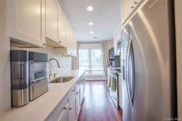 a kitchen with stainless steel appliances granite countertop a refrigerator and a sink