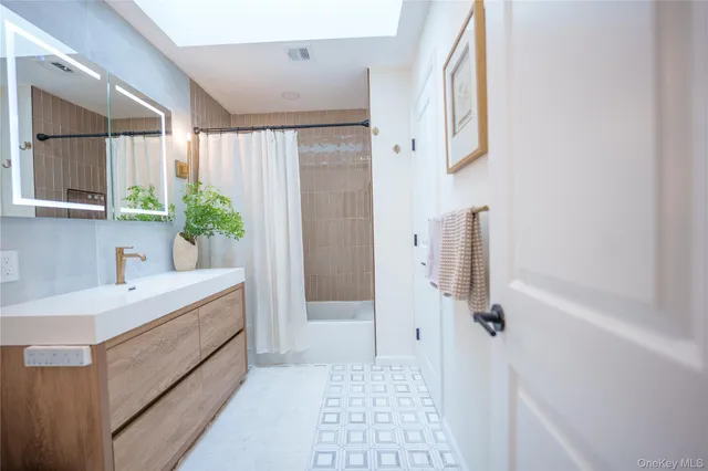 a bathroom with a sink a mirror and a shower