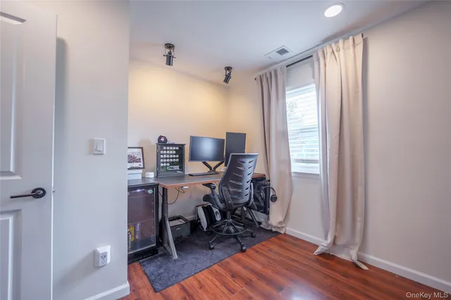 a view of a workspace with furniture and a window