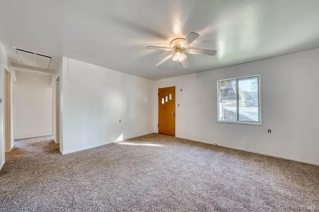 a view of a livingroom with a ceiling fan and window