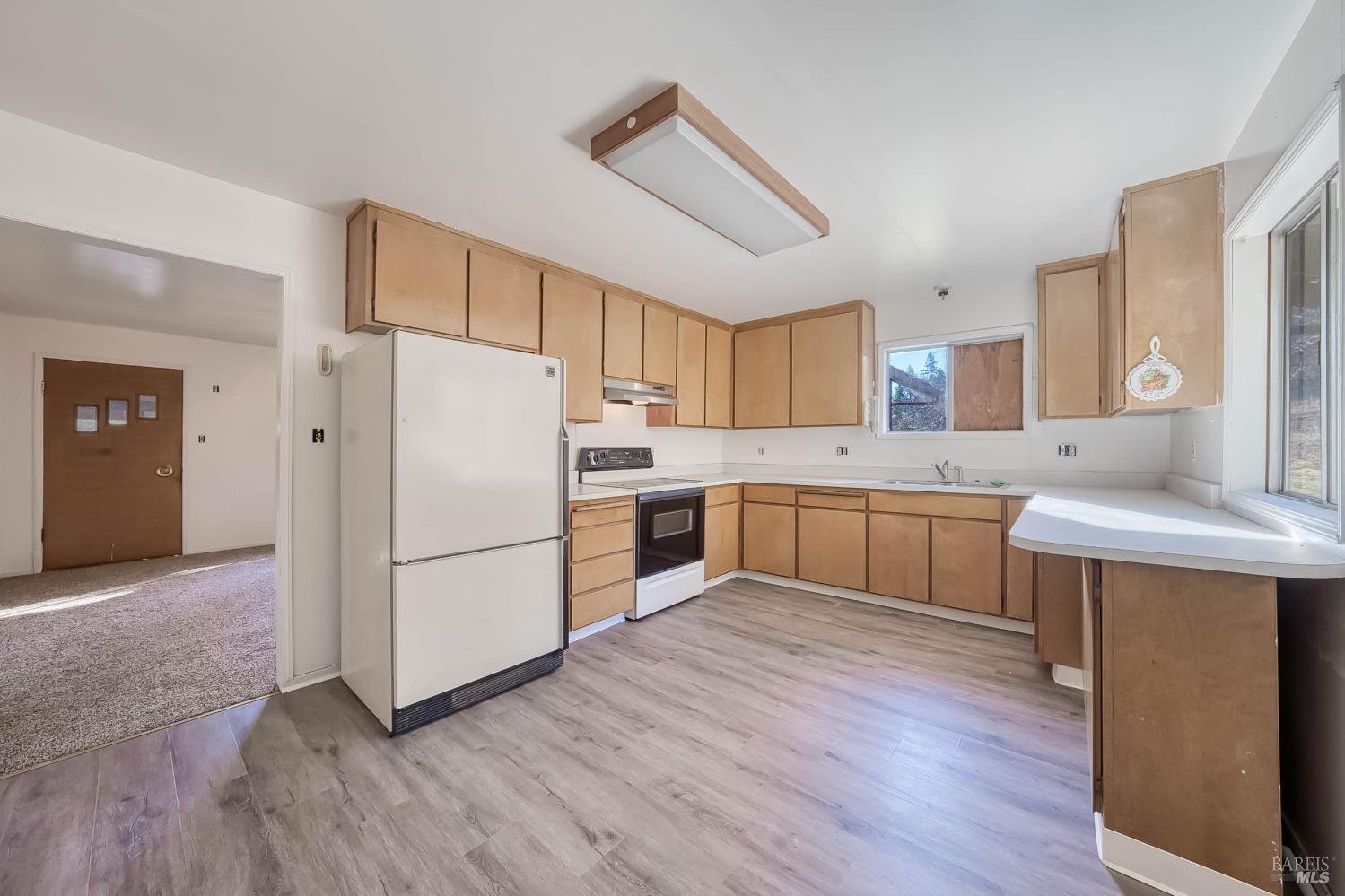 11415 Seigler Springs Road Middletown, CA 95461 - Photo 15 of 52 a kitchen with a refrigerator a sink and cabinets