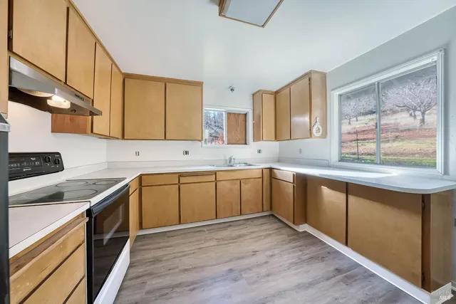 a kitchen with a sink cabinets and wooden floor
