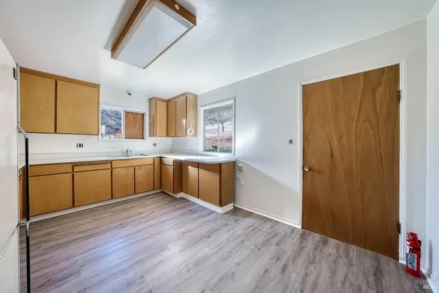 a view of an empty room with a bathroom and a window