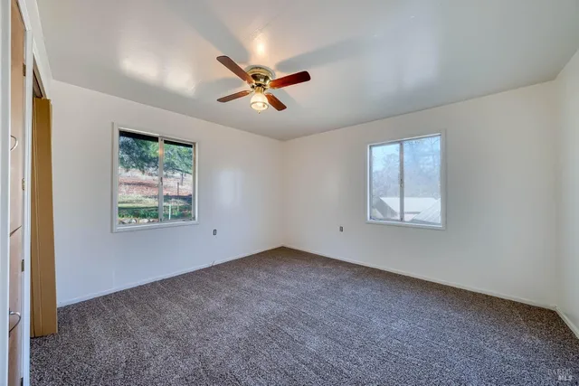 a view of a livingroom with a ceiling fan and window