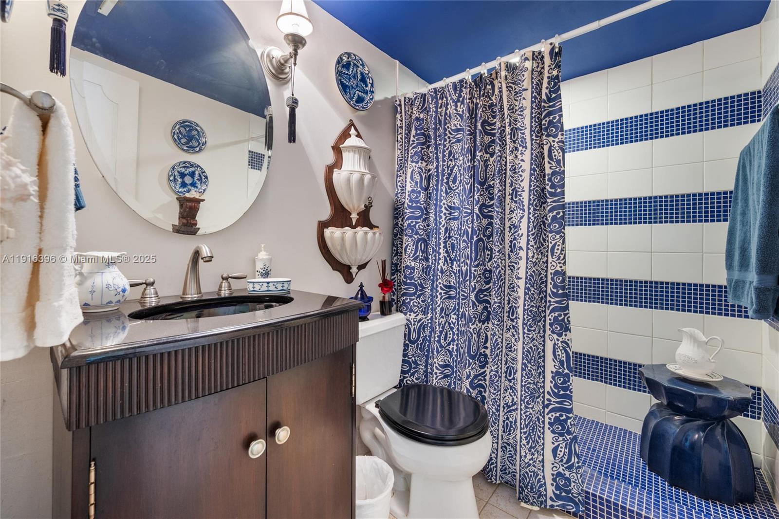 155 Sunrise Drive, Unit 4B Key Biscayne, FL 33149 - Photo 8 of 18 a bathroom with a toilet a sink and mirror