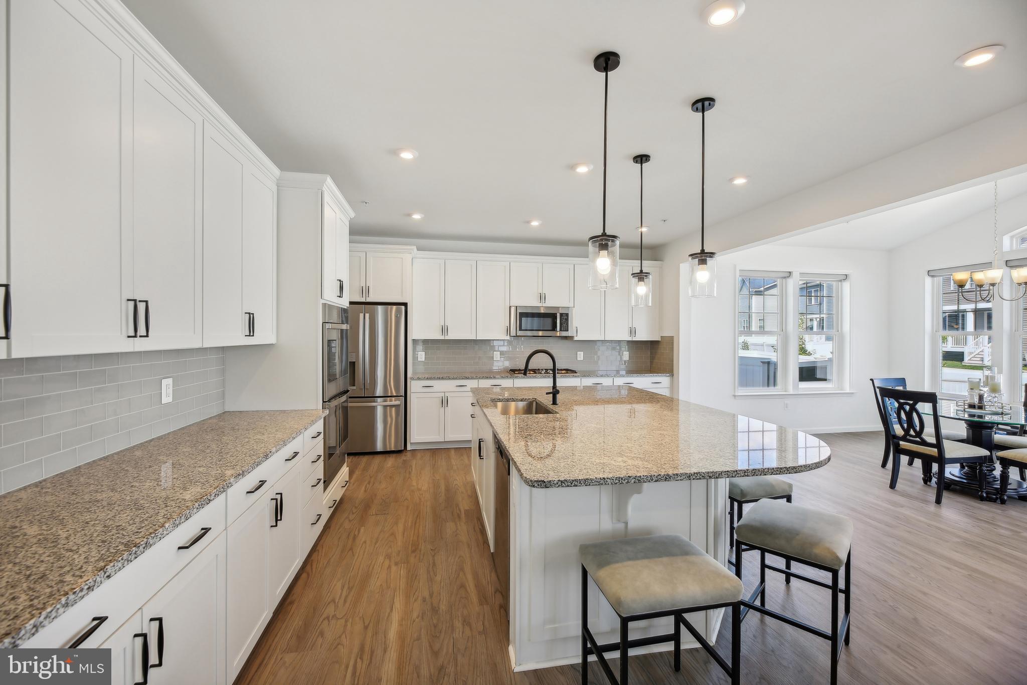 2634 Orchard Oriole Way Odenton, MD 21113 - Photo 14 of 63 a large kitchen with kitchen island a table and chairs