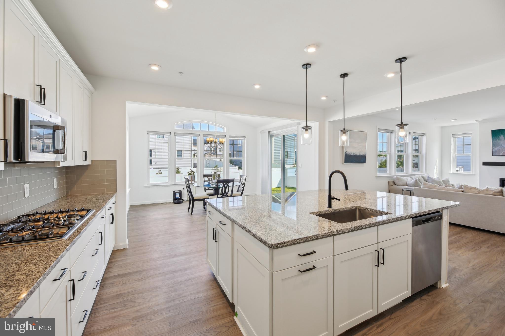2634 Orchard Oriole Way Odenton, MD 21113 - Photo 15 of 63 a kitchen with stainless steel appliances granite countertop a sink a stove and a wooden floors