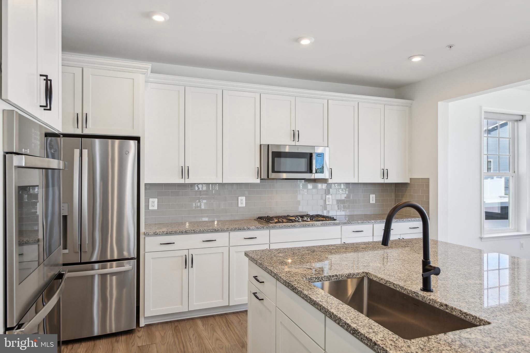 2634 Orchard Oriole Way Odenton, MD 21113 - Photo 17 of 63 a kitchen with granite countertop white cabinets and stainless steel appliances