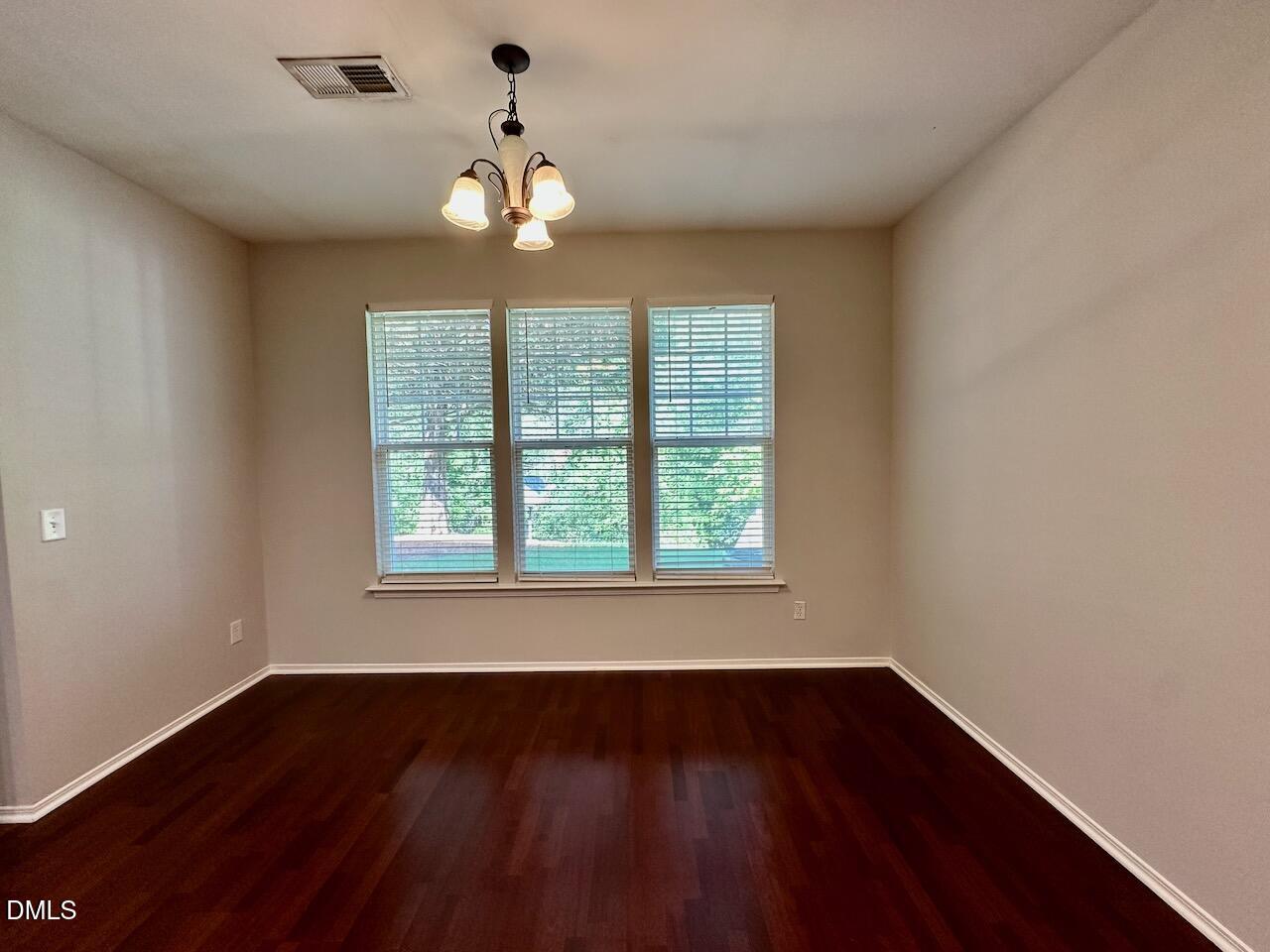 8208 Stone Cellar Drive Raleigh, NC 27613 - Photo 16 of 34 a view of an empty room with wooden floor and a window