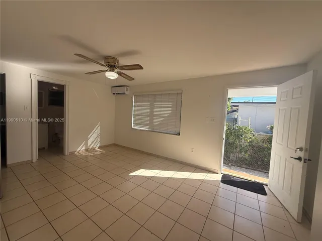 an empty room with windows and ceiling fan
