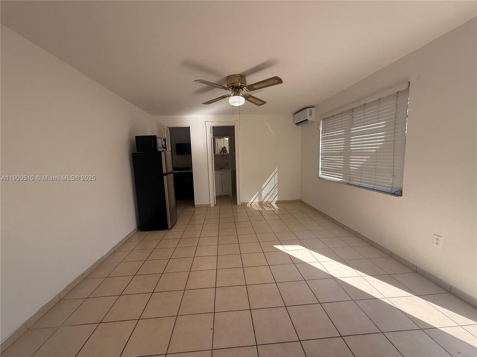 233 Northwest 45th Avenue, Unit E Miami, FL 33126 - Photo 5 of 8 a view of an empty room with a window