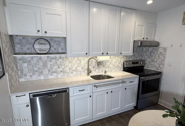 a kitchen with stainless steel appliances granite countertop a sink stove and cabinets