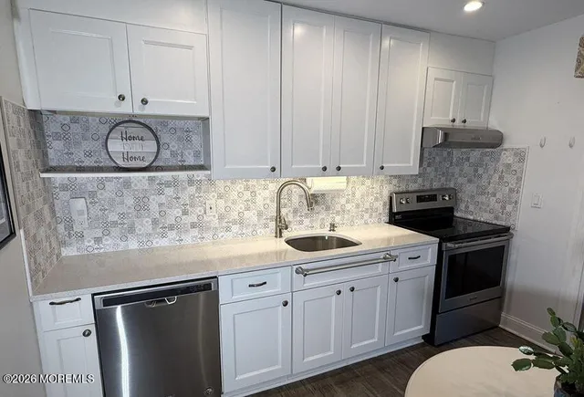 a kitchen with stainless steel appliances granite countertop a sink stove and cabinets