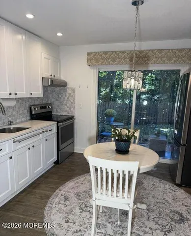 a kitchen with a stove a sink and a dining table