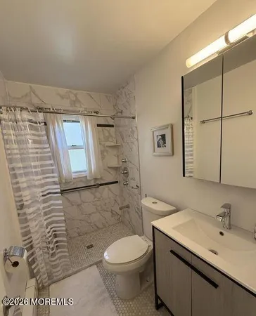 a bathroom with a sink a toilet and shower