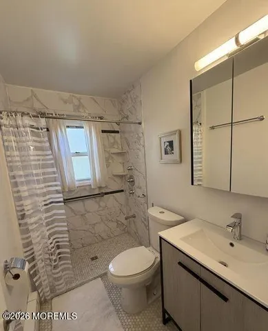 a bathroom with a sink a toilet and shower