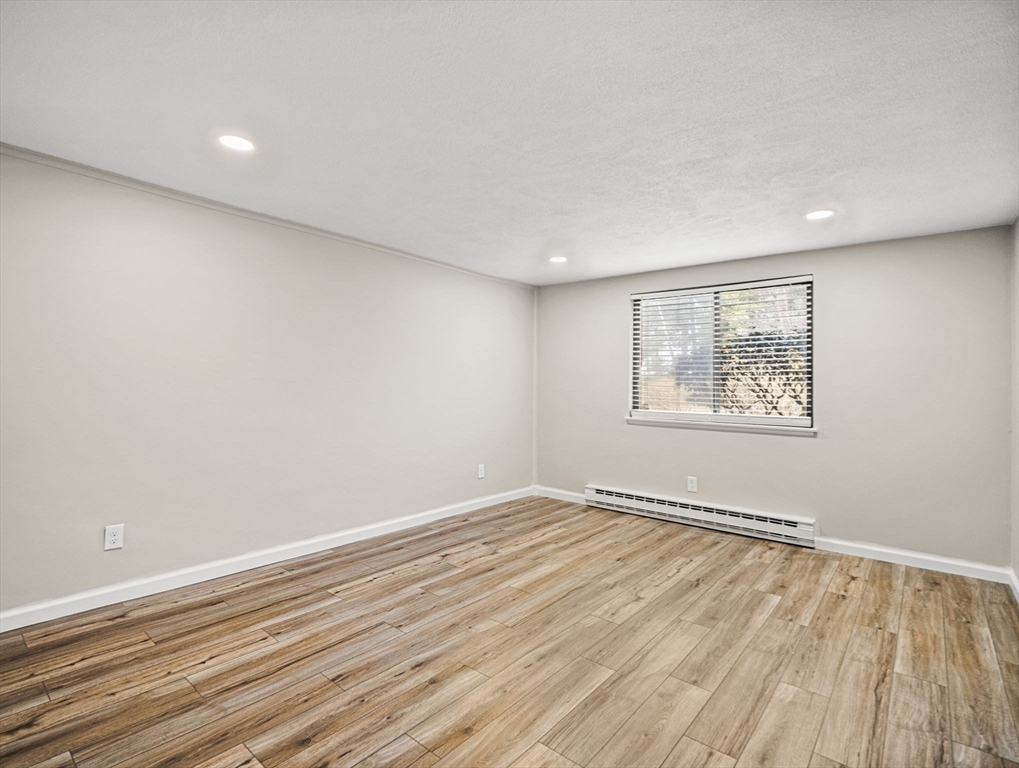 9 Broadway, Unit 110 Saugus, MA 01906 - Photo 16 of 27 an empty room with wooden floor and windows