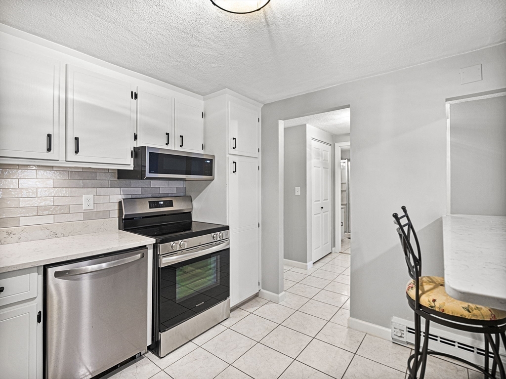 9 Broadway, Unit 110 Saugus, MA 01906 - Photo 7 of 27 a kitchen with cabinets and appliances