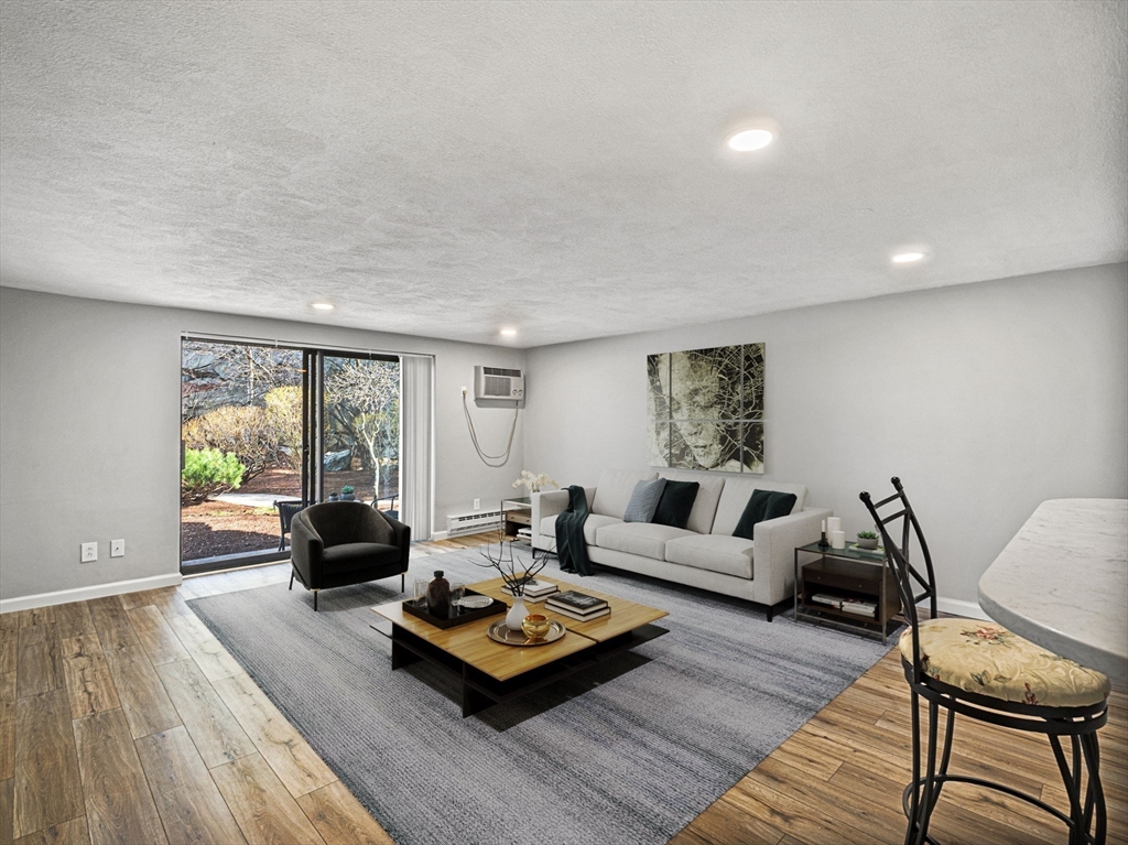 9 Broadway, Unit 110 Saugus, MA 01906 - Photo 10 of 27 a living room with furniture and a wooden floor