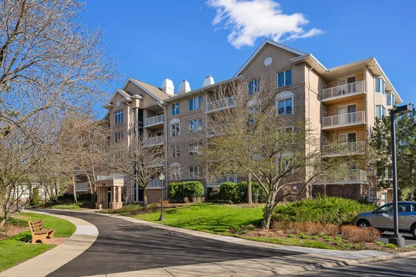 a front view of a building with street view and trees
