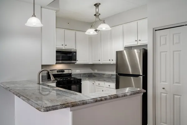 a kitchen with granite countertop a refrigerator oven a sink and dishwasher