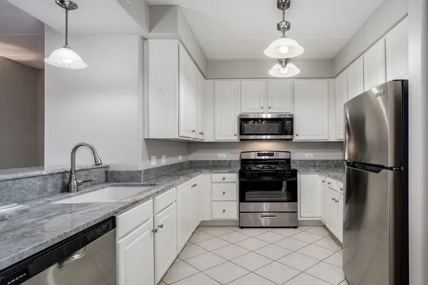 a view of a kitchen island a chandelier and wooden floor