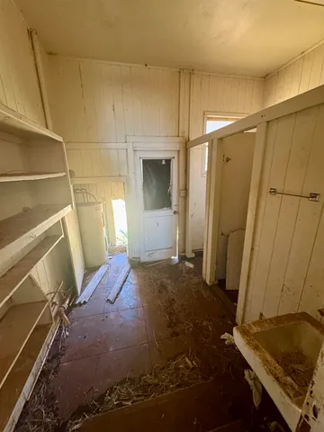 a view of a dry yard with wooden fence