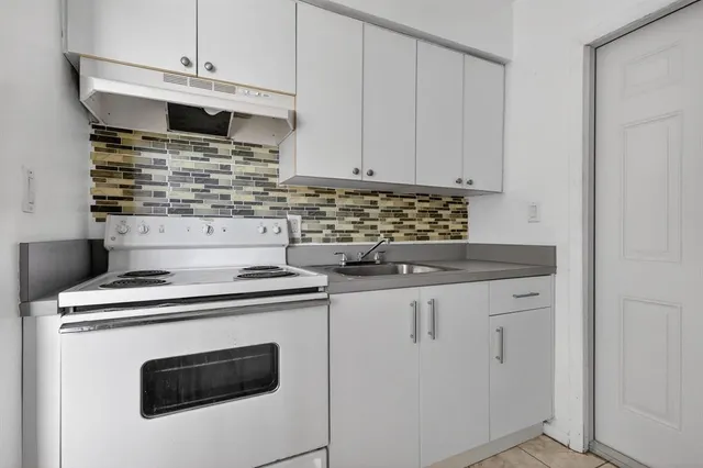 a kitchen with granite countertop white cabinets and white appliances