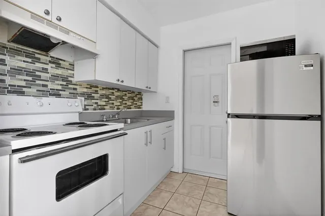 a kitchen with stainless steel appliances granite countertop a refrigerator and a stove