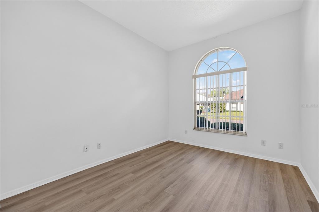 28244 Brokenmead Path Wesley Chapel, FL 33543 - Photo 25 of 37 an empty room with wooden floor and windows