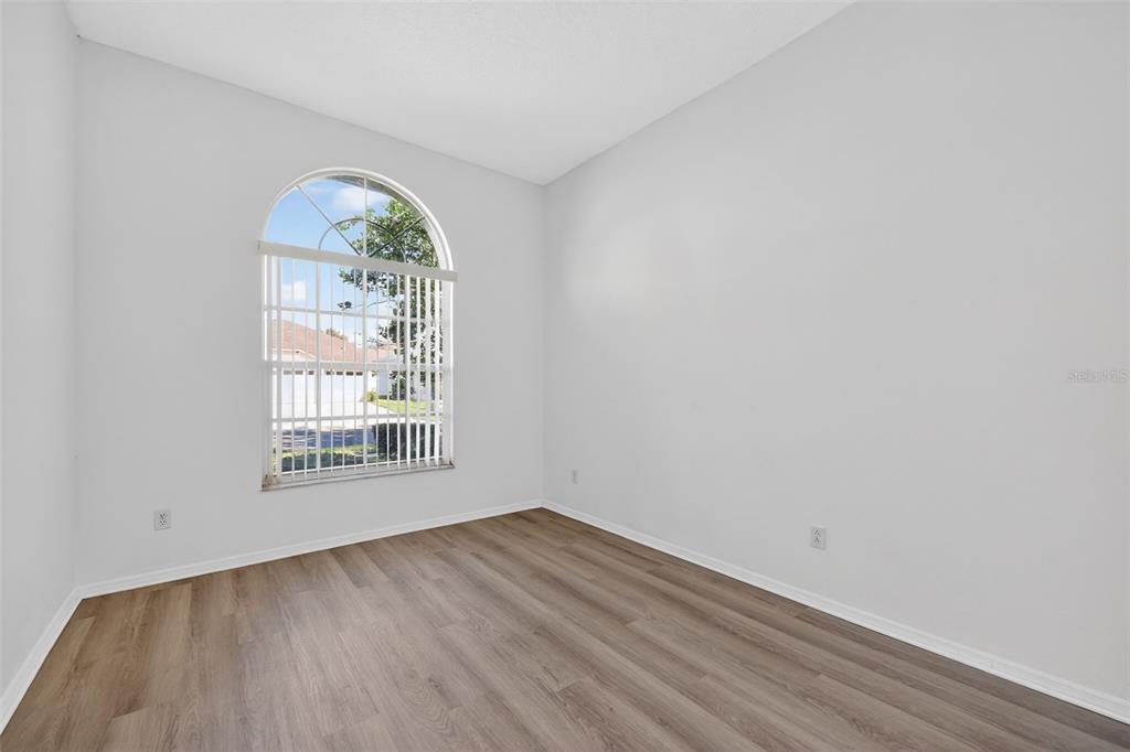 28244 Brokenmead Path Wesley Chapel, FL 33543 - Photo 27 of 37 an empty room with wooden floor and a window