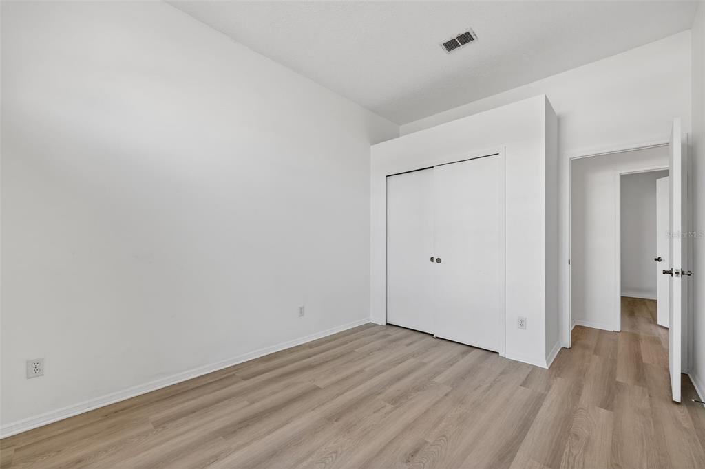 28244 Brokenmead Path Wesley Chapel, FL 33543 - Photo 28 of 37 a view of an empty room with wooden floor