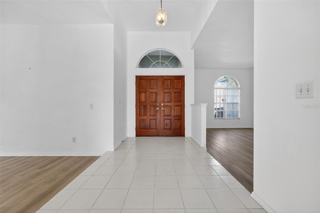 28244 Brokenmead Path Wesley Chapel, FL 33543 - Photo 6 of 37 an entryway to room with wooden floor cabinet and windows