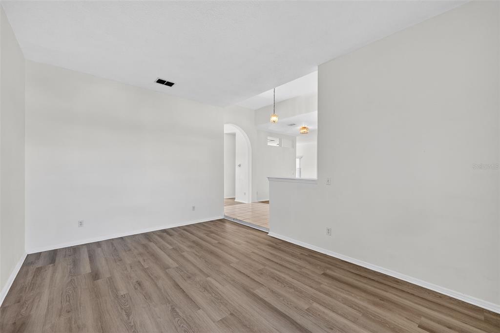 28244 Brokenmead Path Wesley Chapel, FL 33543 - Photo 8 of 37 a view of an empty room with wooden floor and a window