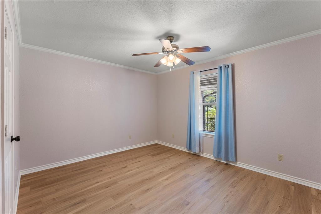 116 Meadowood Road Enchanted Oaks, TX 75156 - Photo 26 of 37 Light-filled room featuring wood-finish flooring, a ceiling fan with integrated lighting, and crown molding