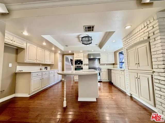a view of empty room with wooden floor and fireplace